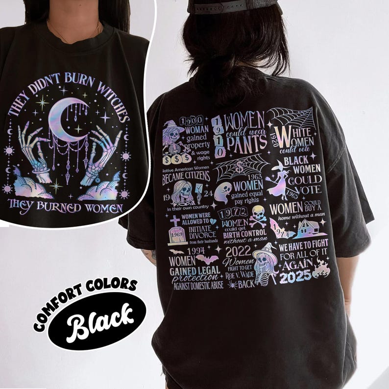 May include: Black graphic t-shirt with the text "THEY DIDN'T BURN WITCHES THEY BURNED WOMEN" and a design of skeleton hands, a crescent moon, and stars. The back of the shirt has a timeline of women's rights. The shirt is labeled "COMFORT COLORS Black".