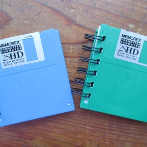 May include: Two blue and green 3.5 inch floppy disks with black spiral binding. The disks are labeled "Memorex Formatted 2SHD High Density Haute Densite 1.44 MB".