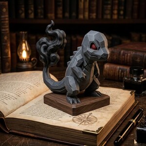 May include: A grey, geometric sculpture of a dragon-like creature with red eyes and a smoky tail, mounted on a wooden base. The sculpture is set on an open book with a compass rose illustration, with a lamp and books in the background.
