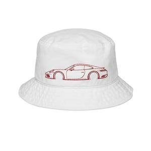 May include: White bucket hat featuring a red embroidered outline of a sports car. The hat has a classic, casual design with a rounded crown and a downward-sloping brim. The car graphic is on the front of the hat.