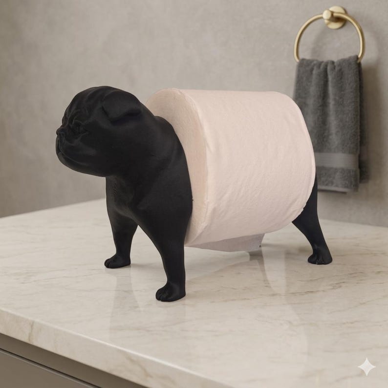 May include: A matte black toilet paper holder shaped like a standing pug dog. The figure features a detailed head with a wrinkled face and pointed ears, with a cylindrical body designed to hold a single roll of white toilet paper horizontally.