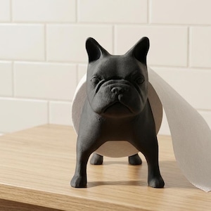 May include: A matte black French bulldog figurine designed as a toilet paper holder. The dog stands in a forward-facing position with a roll of white toilet paper positioned around its midsection, extending out to the right side of the figure.