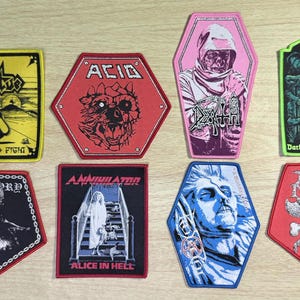 May include: Eight embroidered fabric patches featuring various band logos and graphic illustrations. Designs include Virtue, Acid, Death, Darkness Descends, Bathory, Annihilator Alice in Hell, and Rigor Mortis. The patches are rectangular, hexagonal, and coffin-shaped.