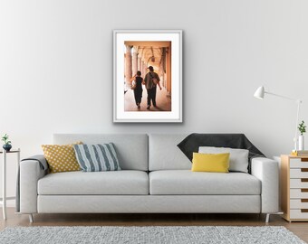 May include: A framed photograph of a couple walking hand-in-hand down a hallway with arched ceilings.