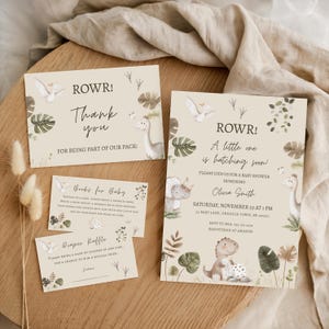 May include: A set of baby shower invitations and cards with a dinosaur theme. The invitation reads "A little one is hatching soon!" and includes details for the event. Additional cards include "Thank you" and "Books for Baby".