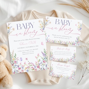 Könnte beinhalten: Babyparty-Einladungen und Karten mit floralen und Schmetterlingsmotiven. Die Einladung lautet "Baby in Bloom" und enthält Veranstaltungsdetails. Ein Teddybär und ein Baby-Body sind im Hintergrund.