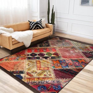 May include: A rectangular patchwork rug with a dark brown border. The rug features a variety of colors including red, orange, blue, and beige. The design incorporates geometric patterns and a distressed aesthetic, suitable for a living room.
