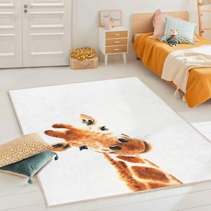 May include: A rectangular white rug featuring a watercolor illustration of a giraffe's head and neck. The giraffe has brown and tan spots and a long neck. The rug is placed on a white floor, with pillows and a bed in the background.
