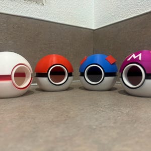 May include: Four Poke Balls, each with a different colour and design. The Poke Balls are white with a red, blue, purple, and black design. The Poke Balls are made of plastic and have a hole in the top.