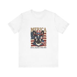 Peut inclure: T-shirt blanc avec un motif patriotique. Le graphisme représente un bouledogue français portant des lunettes de soleil et un chapeau, tous deux décorés du drapeau américain. Le mot "'Merica" est au-dessus du chien, et le texte "Liberty, Equality & Belly Rubs" est en dessous.