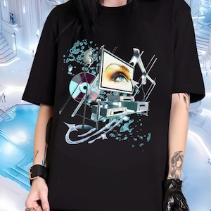 Puede incluir: Camiseta negra con un estampado gráfico de una pantalla de televisión con un ojo azul y un tocadiscos. El fondo es un diseño abstracto azul y blanco.
