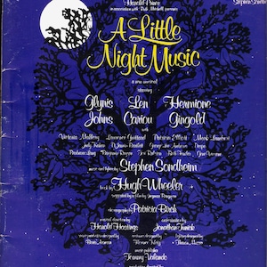 May include: A blue and black program cover for the musical "A Little Night Music" starring Glynis Johns, Len Cariou, and Hermione Gingold. The cover features a stylized tree with a full moon in the background.