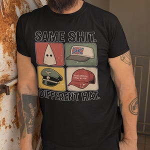 May include: Black t-shirt with the text "SAME SHIT. DIFFERENT HAT." The shirt features four images: a white hood, a Confederate flag hat, a military hat, and a "Make America Great Again" hat.