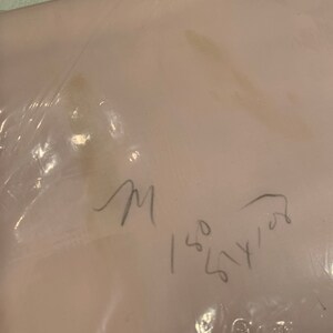 May include: A close-up of a light pink fabric with a handwritten note that says "M 150 54 102".