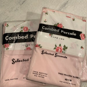 May include: Two packages of pink and white floral printed pillowcases. The packaging says "Combed Percale" and "Selected Seconds". The pillowcases are 100% cotton and measure 42 x 38 inches.