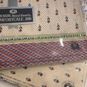 May include: A white and cream patterned fitted sheet with a floral design. The packaging includes the brand name "Cannon Royal Family" and the text "Comfortcale 200". The sheet is made of 60% combed Pima cotton blend and 40% polyester. The sheet is for a 54x76 inch mattress (137x193 cm).
