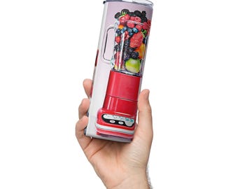 May include: A red blender with a clear container filled with a variety of fruits and berries. The blender is on a white background.