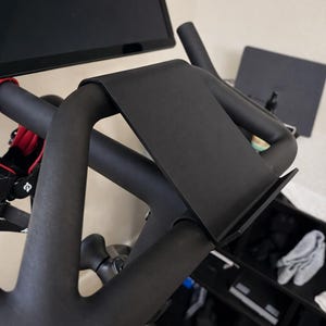 May include: A white ceramic mug with a black handle and the text "But First, Coffee" in a bold, black font. The mug is sitting on a wooden surface. The mug is approximately 4 inches tall.