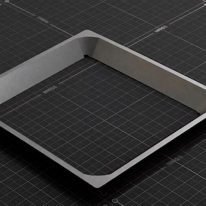 May include: A square, light gray metal frame with rounded corners, set against a dark gray grid background. The frame has a raised, angled edge, creating a three-dimensional effect. The overall design is minimalist and industrial.
