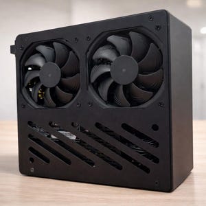 Może przedstawiać: Czarna obudowa komputera z dwoma dużymi wentylatorami chłodzącymi. Wentylatory są wyśrodkowane na przednim panelu, a obudowa ma prostokątny kształt z ukośnymi otworami wentylacyjnymi u dołu.