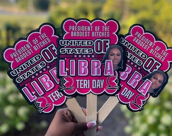 May include: Three pink and black Libra-themed fan decorations with the text "President of the Baddest Bitches" and "United States of Libra." Each fan features a portrait of a woman and the words "Teri Day."