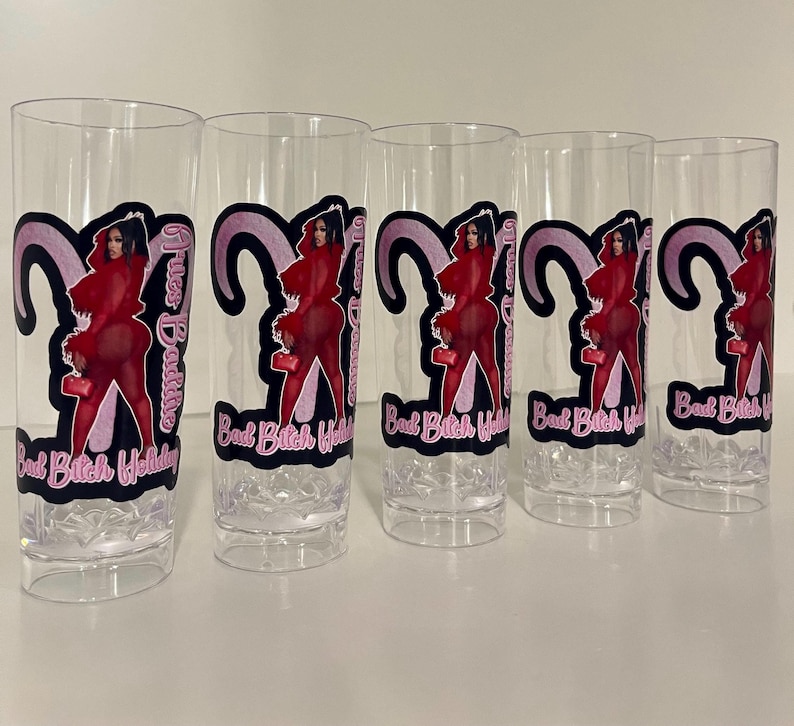Pu&ograve; includere: Cinque bicchieri alti trasparenti con una stampa grafica di una persona in un completo rosso e un design a corna di ariete rosa. Il testo "Aries Baddie" e "Bad Bitch Holiday" &egrave; stampato in lettere rosa e bianche su ogni bicchiere.