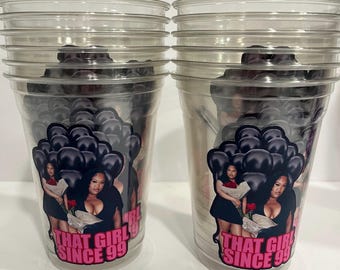 May include: Two clear plastic disposable cups featuring a graphic decal of a person in a black dress holding red roses against a background of black balloons. The text "THAT GIRL SINCE 99" is printed in bold pink letters at the bottom of the decal.