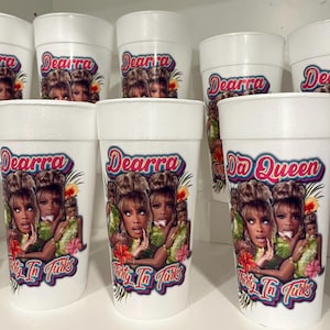 May include: A collection of white foam cups featuring a colorful graphic print. The design includes the text Dearra and Thirty In Turks, alongside an image of a person with blonde hair, tropical flowers, and green foliage accents.