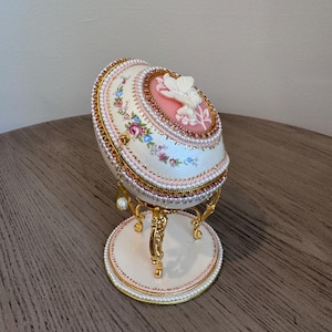 手作りのファベルジェの卵型ジュエリーボックス、ピンクとゴールドの花飾り