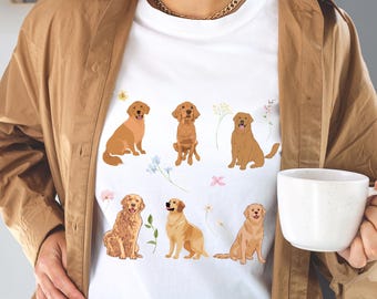 以下が含まれることがあります： 花柄のアクセントがついたゴールデンレトリバーの犬6匹のグラフィックがプリントされた白いTシャツ。犬は座ったり、立ったり、走ったりと様々なポーズをとっています。