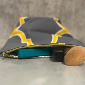 Estuche de maquillaje con cremallera: diseño geométrico gris y amarillo