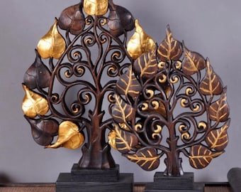 May include: Two decorative tree sculptures with intricate leaf and branch designs. The leaves are a mix of gold and brown, with dark brown branches and trunks. Each tree sits on a black rectangular base, suitable for home decor.