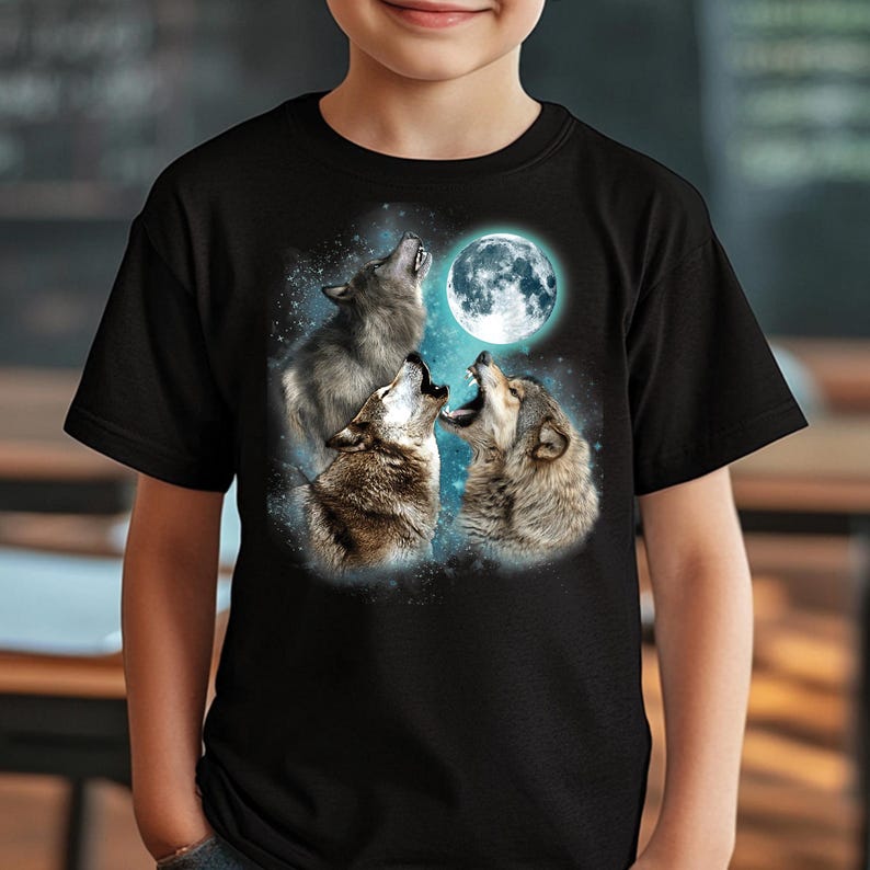 May include: Black t-shirt with a graphic of three wolves howling at a full moon. The wolves are silhouetted against a blue and white starry sky.