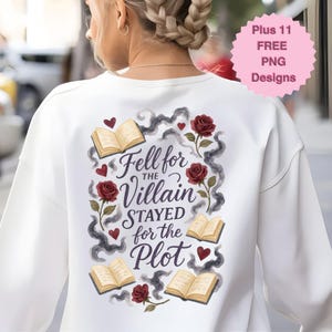 May include: White sweatshirt with a graphic design on the back. The design includes the text "Fell for the Villain, Stayed for the Plot" with roses, hearts, and open books. A pink circle with text is in the upper right corner.