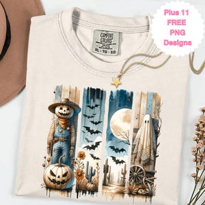 May include: Cream-colored Comfort Colors t-shirt with a Halloween-themed graphic. The graphic features a scarecrow with a pumpkin head, bats, a full moon, and a ghost. A gold star necklace is draped on the shirt. The text "Plus 11 FREE PNG Designs" is visible.
