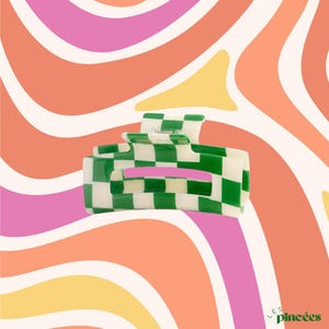 Peut inclure: Pince à cheveux à carreaux verts et blancs. La pince est en plastique et a une finition lisse et brillante.