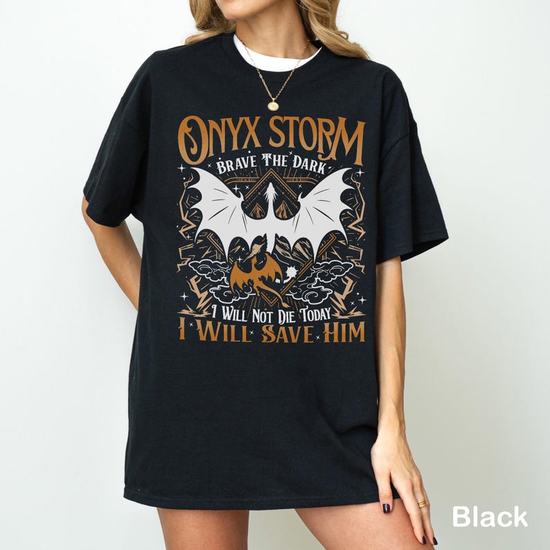 May include: Black t-shirt with a graphic design featuring a dragon with outstretched wings, the text "ONYX STORM BRAVE THE DARK", and the quote "I WILL NOT DIE TODAY I WILL SAVE HIM".