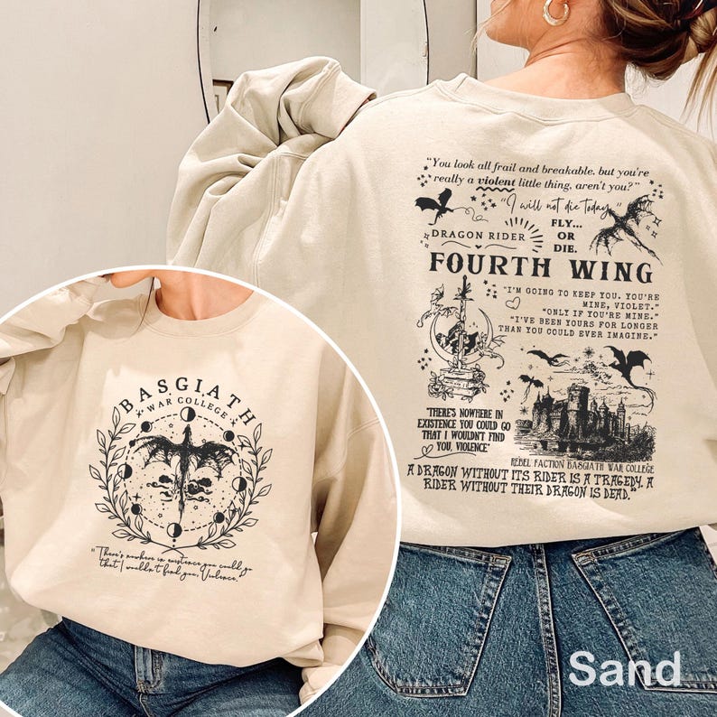 May include: Sand-coloured sweatshirt with graphics from "Fourth Wing." The front has a circular design with a dragon and "Basgiath War College." The back features quotes and illustrations, including dragons and text. The sweatshirt is made of a soft material, perfect for fans of the book.