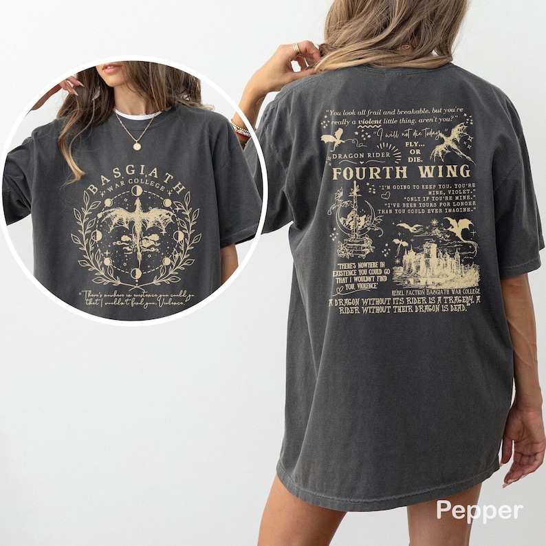 May include: Pepper-coloured t-shirt with a Basgiath War College design, including a dragon and moon phases. The back of the shirt features text about Dragon Riders and the Fourth Wing. A unique graphic tee.