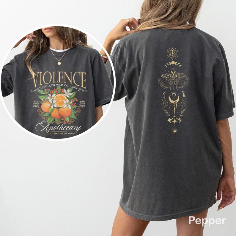 May include: Dark grey t-shirt with a graphic on the front that reads "VIOLENCE Basgiath War College Apothecary Toxic Temptations Await" with orange fruit and floral elements. The back features a gold design with celestial and moth motifs.