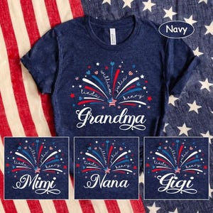 Puede incluir: Camiseta azul marino con un diseño de fuegos artificiales en rojo, blanco y azul, con nombres y la palabra "Grandma" en escritura blanca. Las opciones incluyen diseños "Mimi", "Nana" y "Gigi".