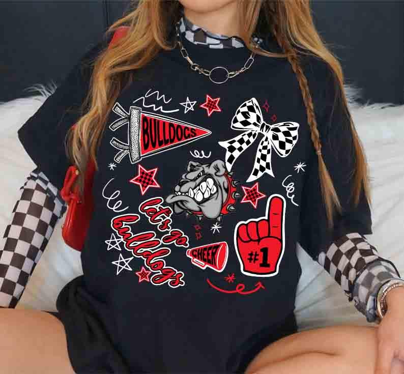 May include: Black t-shirt with a graphic design featuring the word "Bulldogs", a bulldog mascot, stars, and a foam finger with the number one. The design includes red, white, and black elements. The shirt has short sleeves.