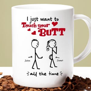 Puede incluir: Taza de cerámica blanca con un gráfico humorístico. La taza presenta figuras de palitos y el texto "I just want to Touch your BUTT all the time" en rojo y negro. Una divertida idea para regalo.