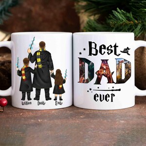 May include: Two white ceramic mugs. One mug features a family of four in black robes with wands, the text "William Daddy Emily" is below the figures. The other mug says "Best DAD ever" with a wizard hat and stars.