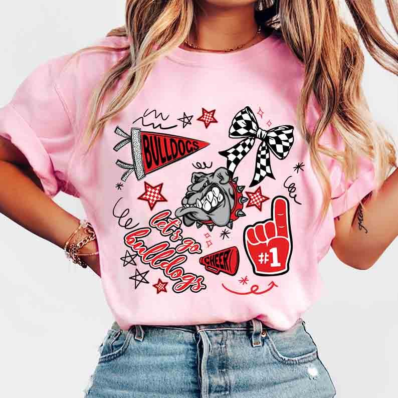 May include: Pink t-shirt with a graphic design featuring a bulldog, stars, a bow, and the words "Let's Go Bulldogs". The design includes a red foam finger with the number one.