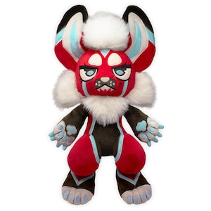 Peut inclure: Une peluche représentant une créature avec un visage, des oreilles et des jambes rouges, rehaussés de détails noirs, blancs et bleu clair. La peluche a une crinière blanche et duveteuse et une expression sévère. Le corps est marron avec des accents rouges et des coussinets bleus.