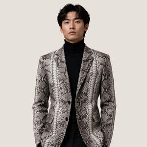 May include: A gray and white snakeskin-patterned blazer with a black turtleneck. The blazer has two black buttons and two front pockets. The outfit is completed with black pants.