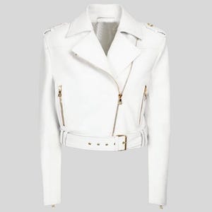 May include: A white leather moto jacket with a gold zipper and belt. The jacket has a cropped length and long sleeves.