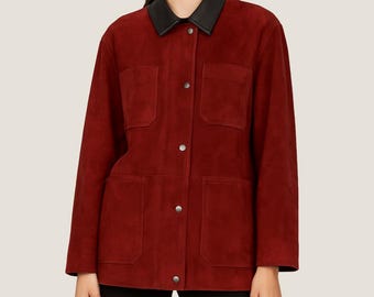 Puede incluir: Chaqueta de ante roja con cuello de cuero negro. La chaqueta tiene cuatro bolsillos delanteros y cierres de botón plateados. Las mangas son largas y el estilo es un diseño clásico e informal.