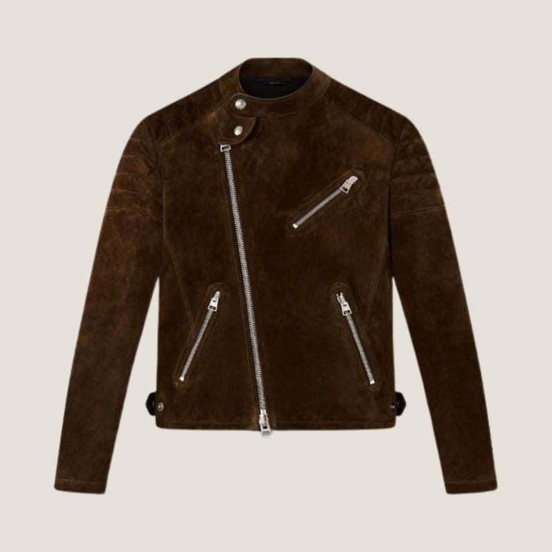 May include: A brown suede jacket with a classic biker style. The jacket features a diagonal zipper, multiple zippered pockets, and a snap-closure collar. The jacket has a textured appearance and a tailored fit.